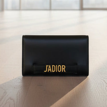 Black wallet with 'J'ADIOR' branding on a light gray background